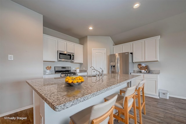 kitchen featuring appliances with stainless steel finishes, dark wood-style flooring, a sink, and white cabinets