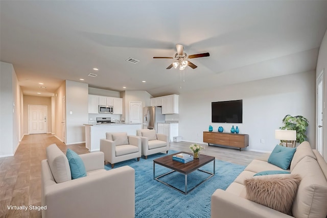 living area featuring light wood finished floors, baseboards, visible vents, a ceiling fan, and recessed lighting