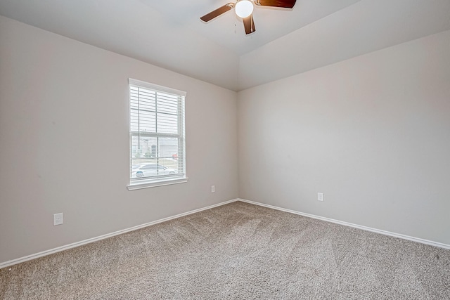 empty room with a ceiling fan, carpet, vaulted ceiling, and baseboards