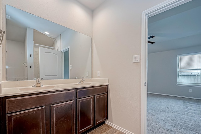 full bathroom with double vanity, a sink, and baseboards