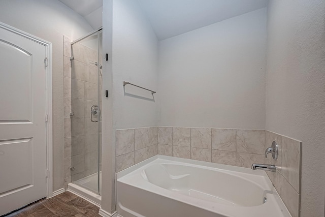 bathroom with a garden tub, wood finished floors, and a shower stall