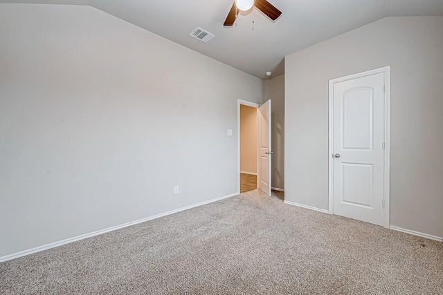 unfurnished bedroom featuring ceiling fan, carpet flooring, visible vents, baseboards, and vaulted ceiling