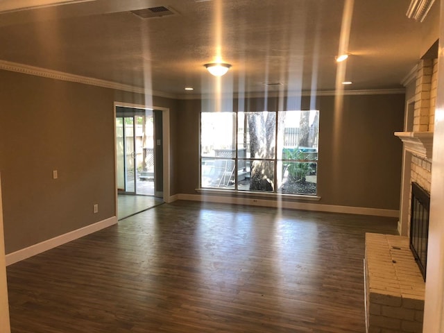 unfurnished living room with ornamental molding, a brick fireplace, baseboards, and wood finished floors