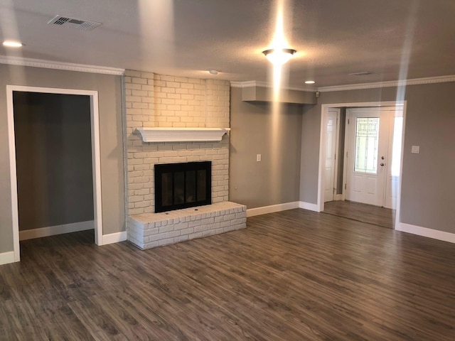 unfurnished living room with a brick fireplace, visible vents, dark wood-type flooring, and ornamental molding