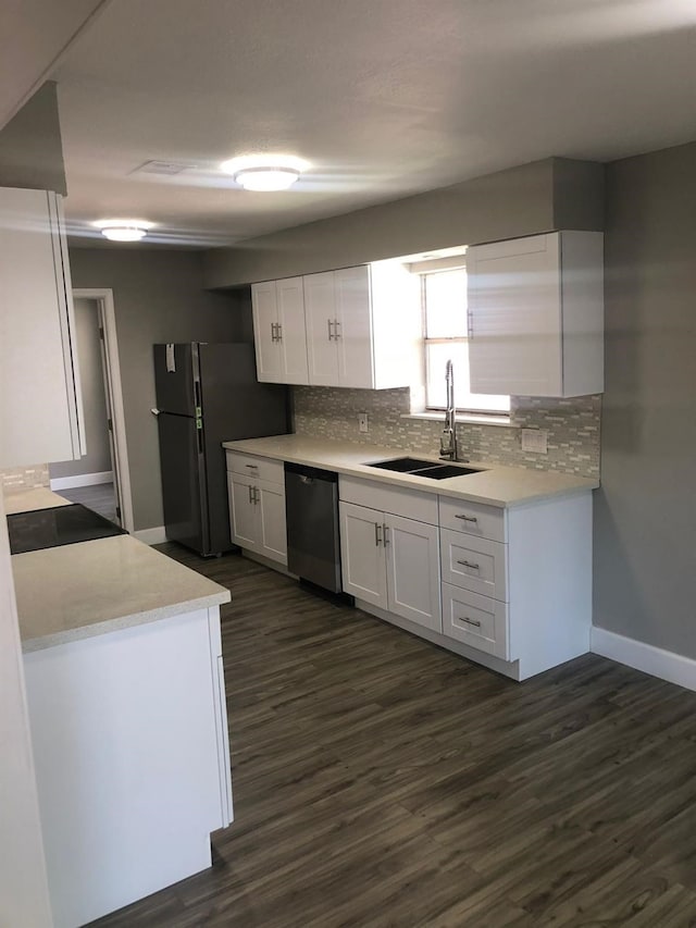 kitchen featuring dark wood finished floors, white cabinetry, dishwasher, and a sink