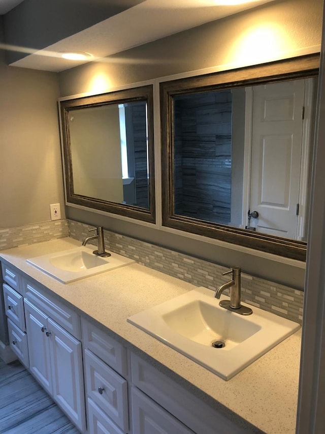 bathroom featuring double vanity, tasteful backsplash, and a sink