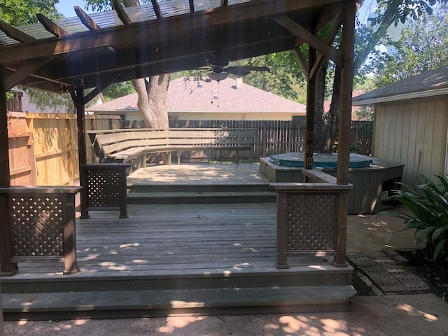 wooden terrace featuring a hot tub, a pergola, and a fenced backyard