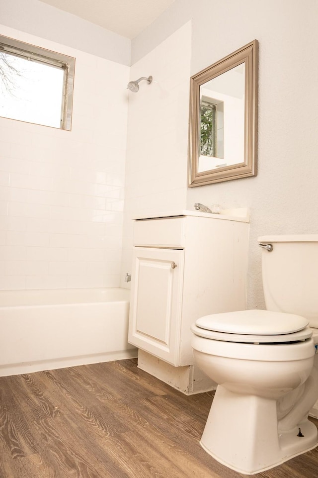 bathroom with vanity, toilet, shower / bath combination, and wood finished floors