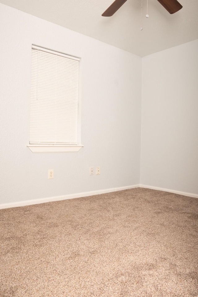 empty room featuring baseboards, carpet floors, and a ceiling fan