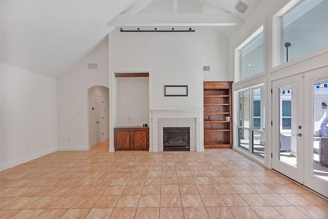 unfurnished living room with visible vents, baseboards, a fireplace, french doors, and light tile patterned flooring