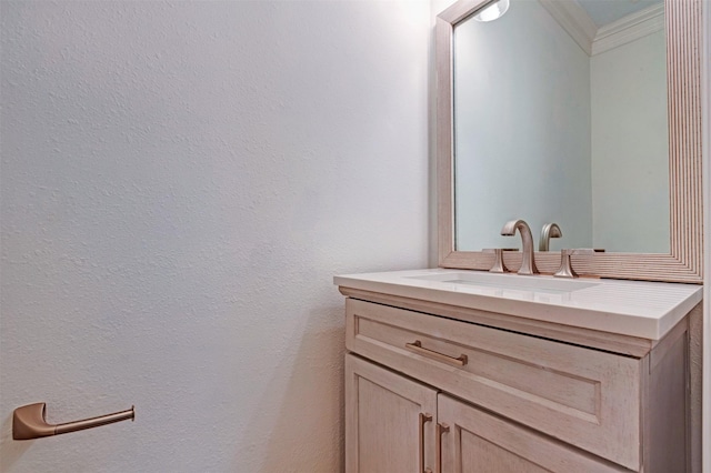 bathroom with vanity, a textured wall, and ornamental molding