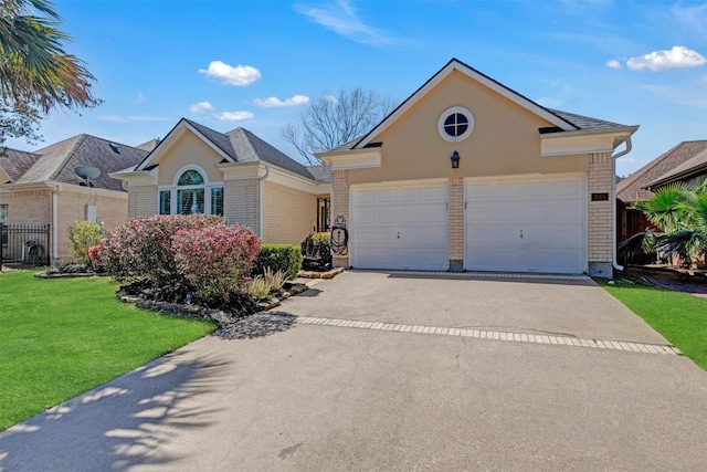 view of front of property featuring brick siding, concrete driveway, and fence