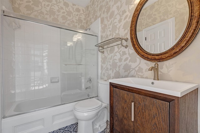 bathroom with combined bath / shower with glass door, toilet, vanity, and wallpapered walls