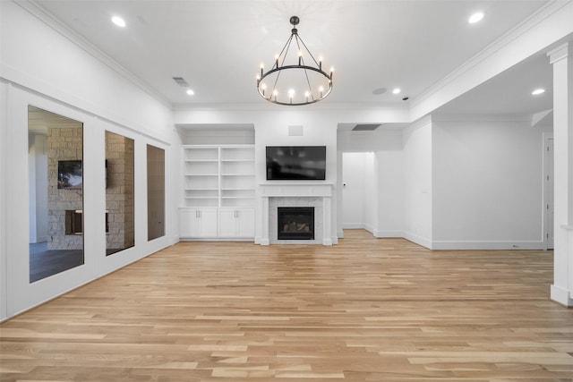 unfurnished living room with light wood-style floors, crown molding, a fireplace, and visible vents