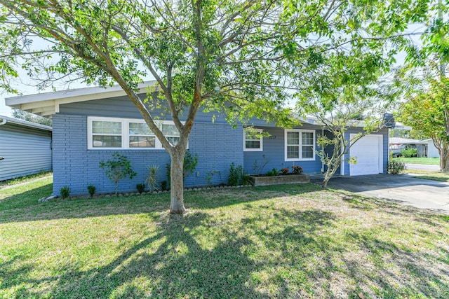 single story home featuring an attached garage, driveway, a front yard, and brick siding