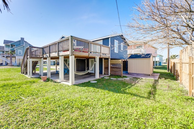 back of house featuring stairs, an outdoor structure, a deck, and a storage unit