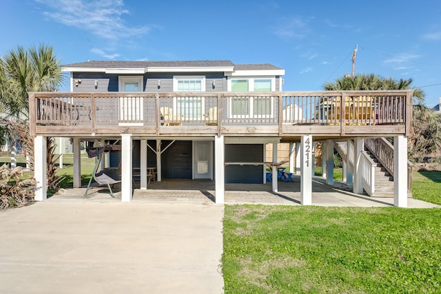 rear view of house featuring stairs, a carport, a yard, and a patio