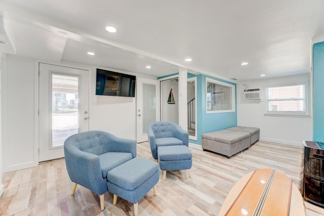 interior space featuring baseboards, light wood finished floors, a wall mounted air conditioner, and recessed lighting