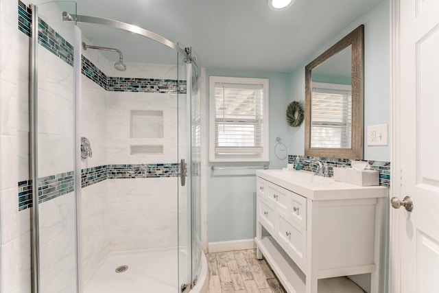 full bath featuring a stall shower, wood finished floors, vanity, and backsplash