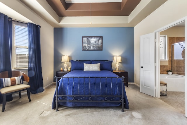 carpeted bedroom featuring a tray ceiling and baseboards