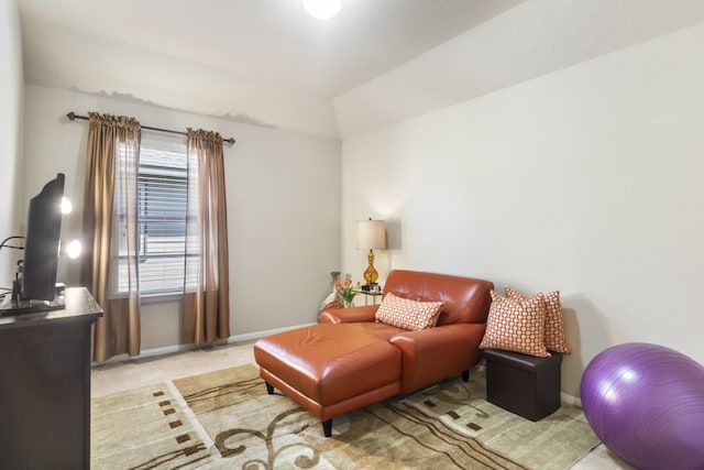 sitting room with baseboards, light colored carpet, and lofted ceiling