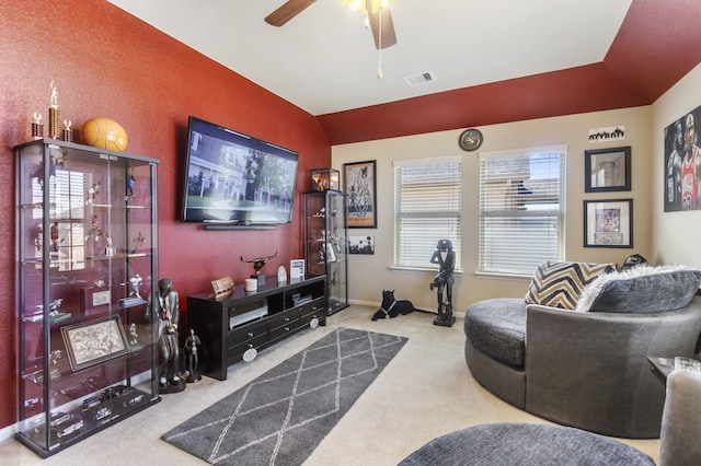 carpeted living room with lofted ceiling, a ceiling fan, visible vents, and baseboards