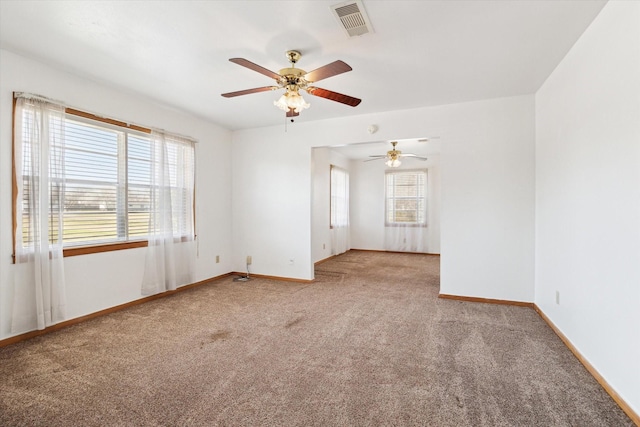 carpeted spare room with visible vents and baseboards