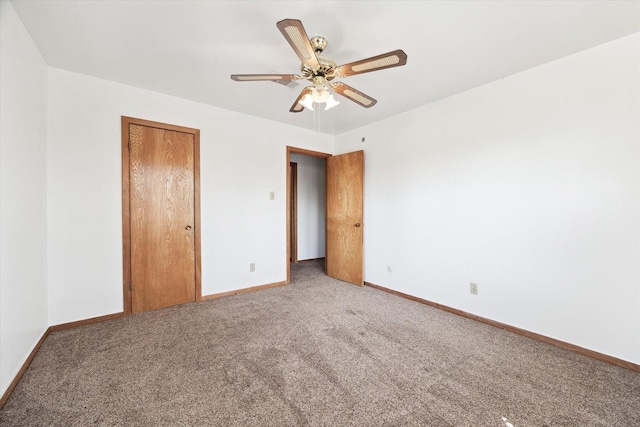 unfurnished bedroom with a closet, carpet flooring, a ceiling fan, and baseboards