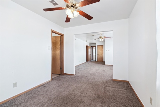 unfurnished room with carpet, visible vents, and baseboards