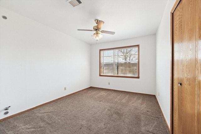 carpeted empty room featuring baseboards, visible vents, and a ceiling fan