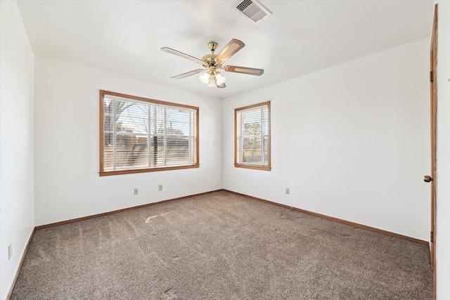 spare room featuring a ceiling fan, carpet flooring, visible vents, and baseboards