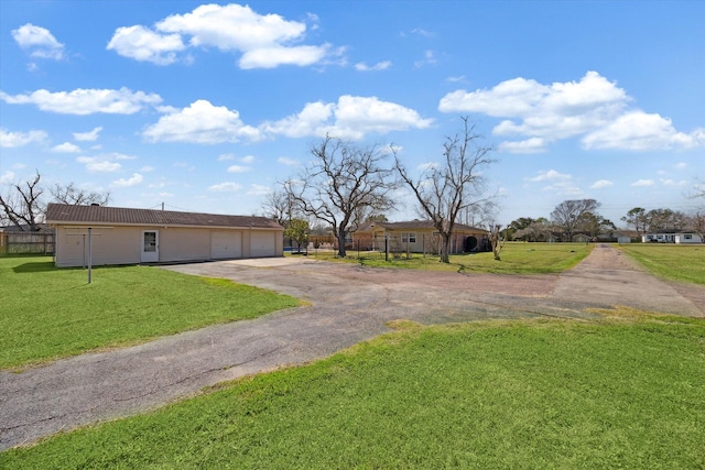 view of front of house featuring a detached garage and a front lawn