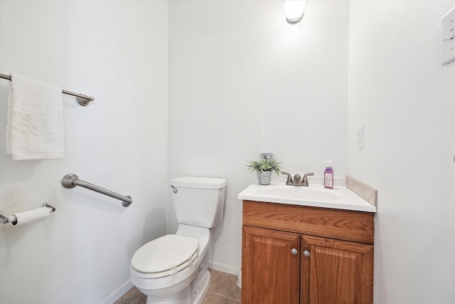 bathroom with tile patterned floors, vanity, toilet, and baseboards