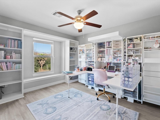 home office featuring visible vents, wood finished floors, a ceiling fan, and baseboards