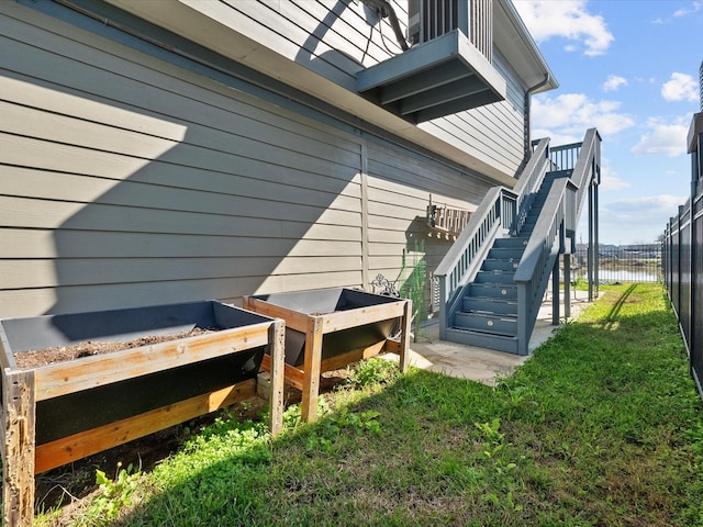 view of property exterior with fence and stairs