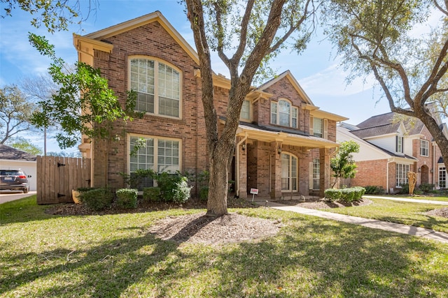 traditional-style house with a front yard and brick siding