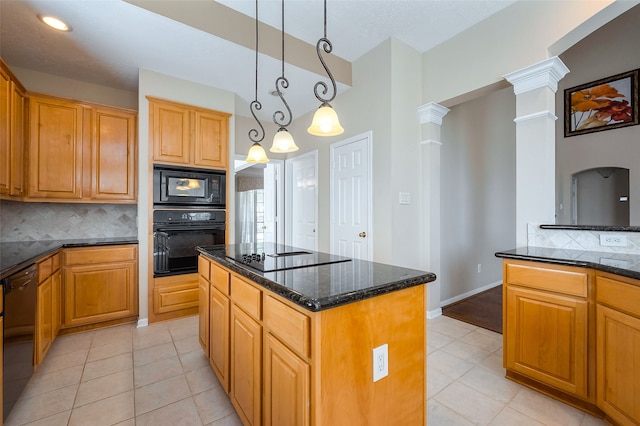 kitchen featuring a kitchen island, dark stone countertops, decorative columns, and black appliances