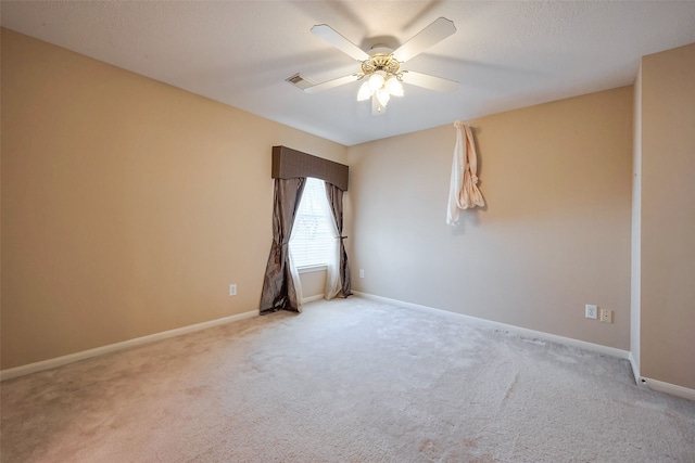 empty room with visible vents, baseboards, ceiling fan, carpet, and a textured ceiling