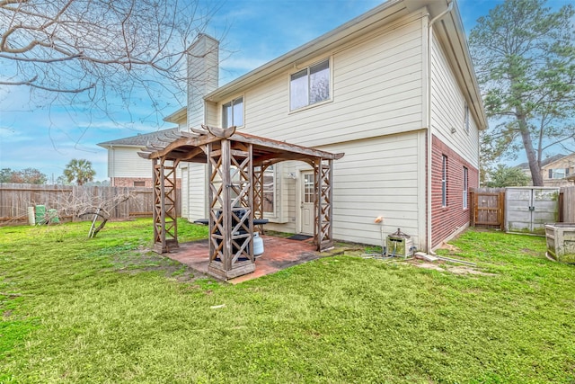 back of house with a fenced backyard, a gate, a pergola, and a patio