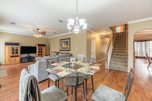 dining room featuring arched walkways, stairway, wood finished floors, and visible vents