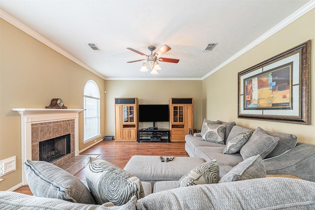 living area featuring visible vents, wood finished floors, and ornamental molding