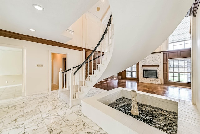 interior space with recessed lighting, a premium fireplace, baseboards, marble finish floor, and stairway