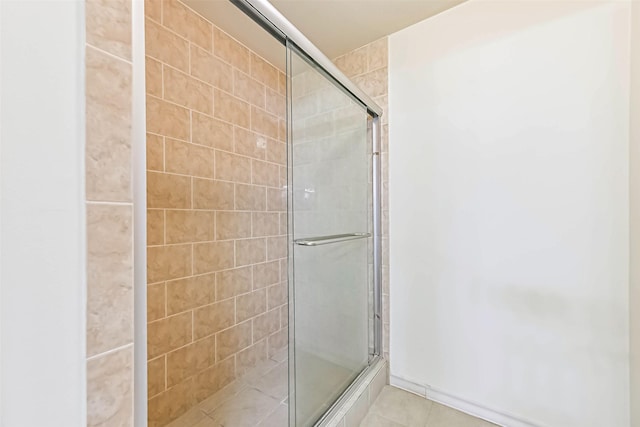 full bath featuring tiled shower and tile patterned floors