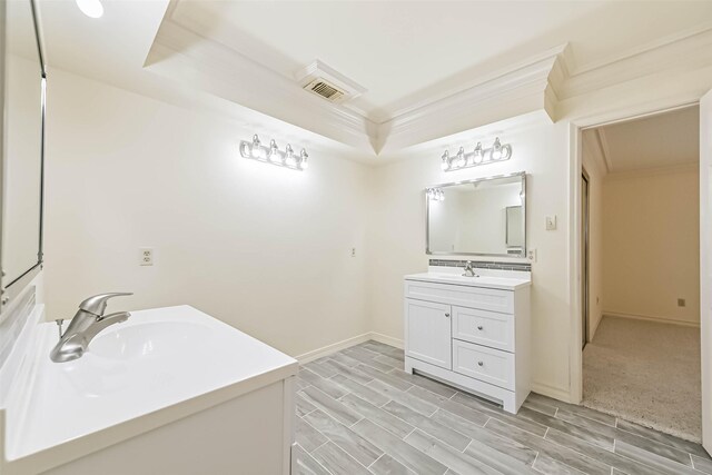 full bathroom featuring a sink, two vanities, baseboards, a tray ceiling, and crown molding