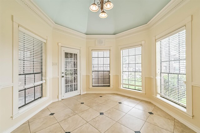 interior space featuring light tile patterned flooring, baseboards, vaulted ceiling, ornamental molding, and an inviting chandelier