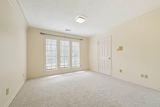 unfurnished room with visible vents, ornamental molding, carpet flooring, a textured ceiling, and baseboards