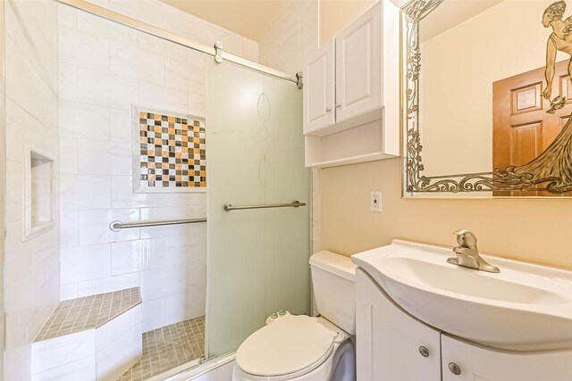 bathroom with a stall shower, vanity, and toilet