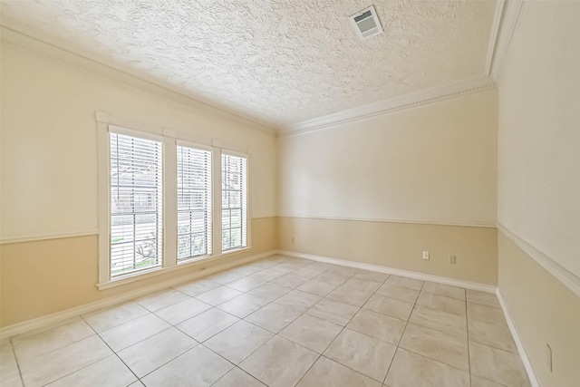 empty room featuring light tile patterned floors, a textured ceiling, visible vents, and crown molding