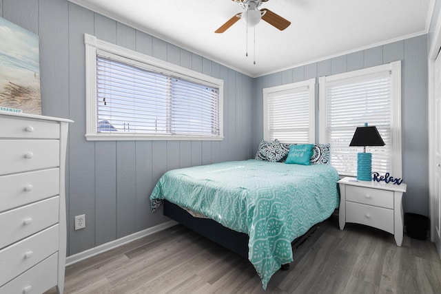 bedroom featuring crown molding, wood finished floors, a ceiling fan, and baseboards