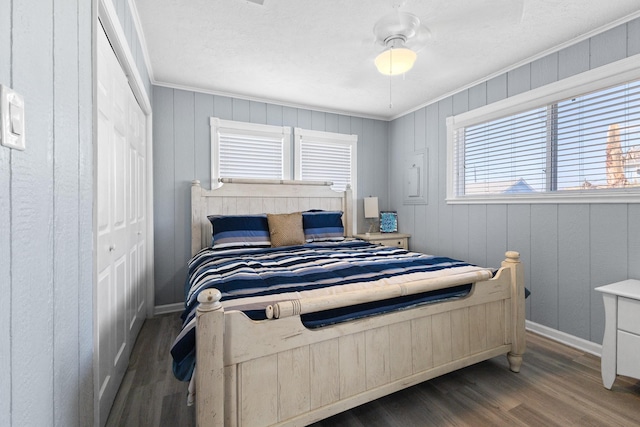 bedroom featuring ornamental molding, a closet, wood finished floors, and baseboards